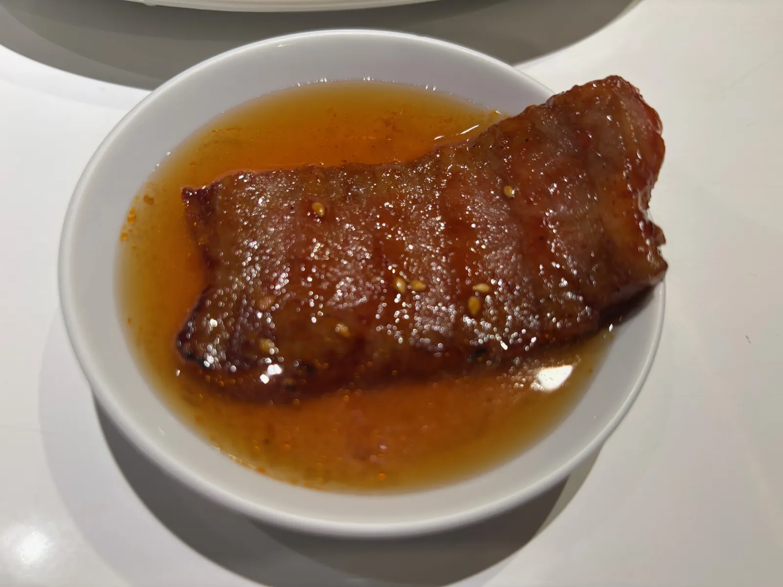 たれの入った小皿に盛られた、焼き上がった肉
