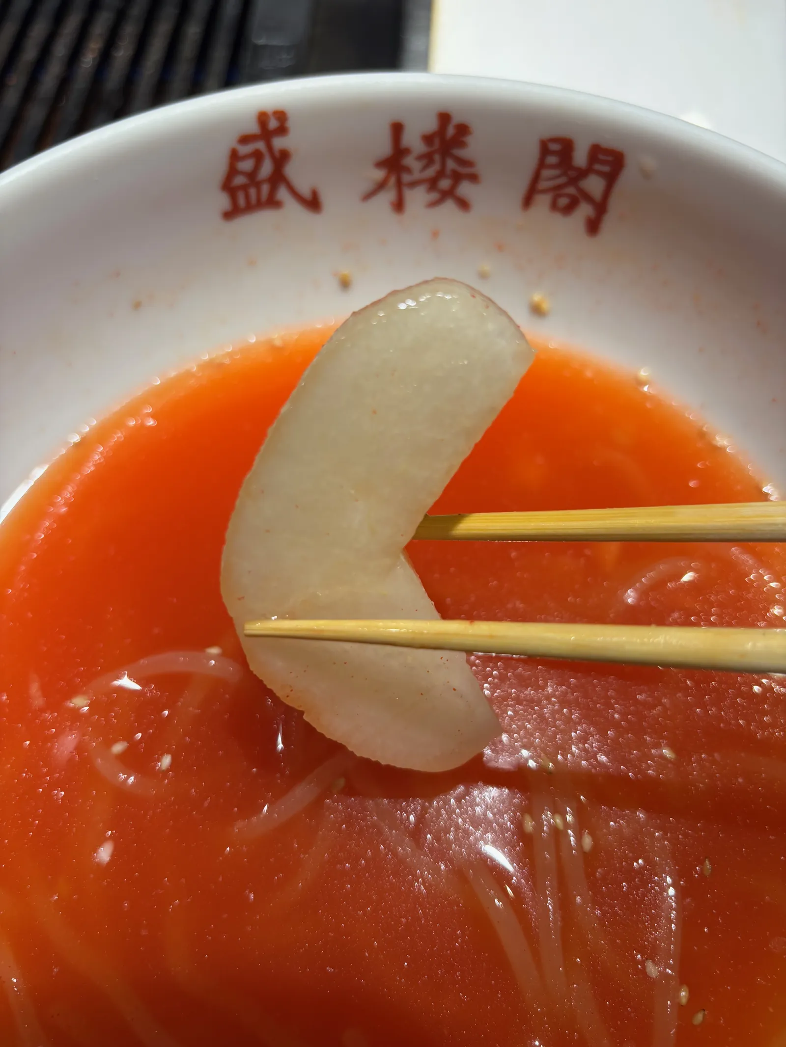 盛岡冷麺の中に入った梨を箸でつまんでいる写真