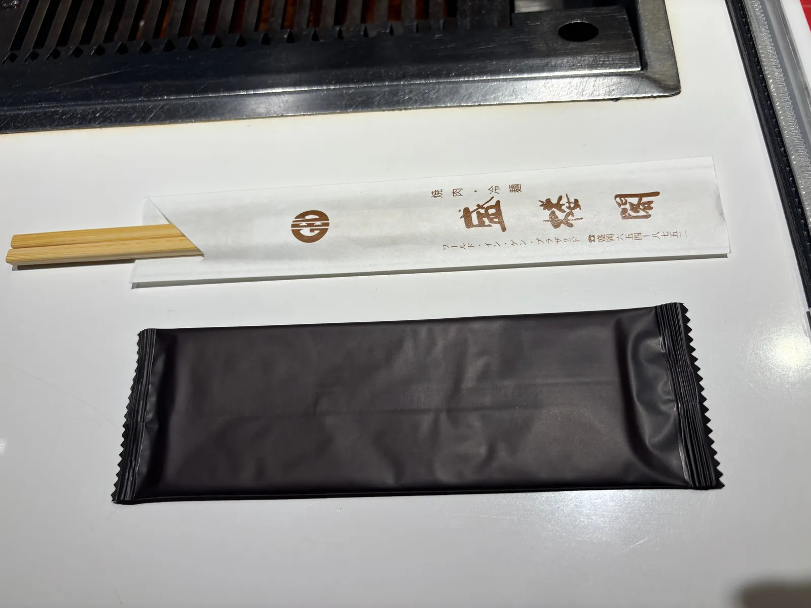 テーブルに置かれたおしぼりと割り箸