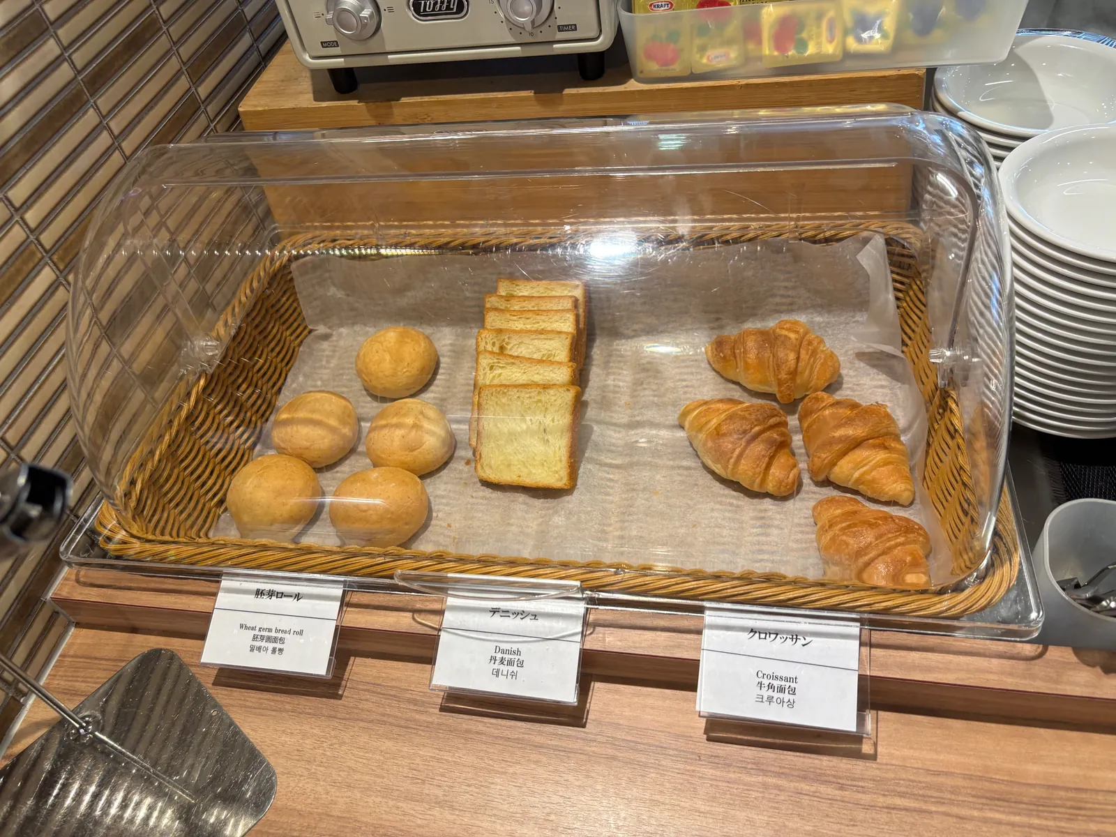 ロールパン、食パン、クロワッサンが並ぶ籠