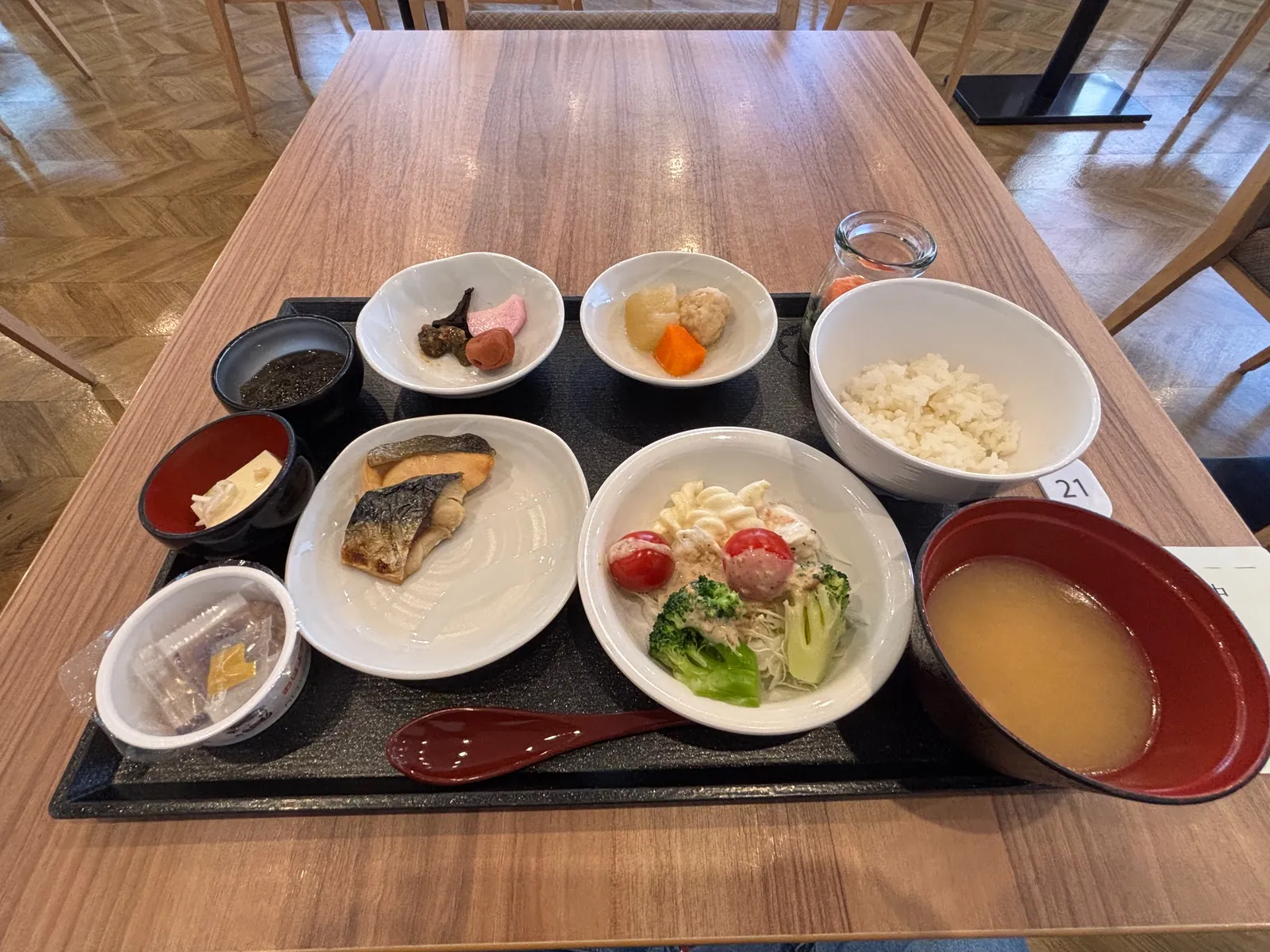 朝食のトレー。焼き魚、ご飯、味噌汁、サラダ、小鉢数品が並んでいる