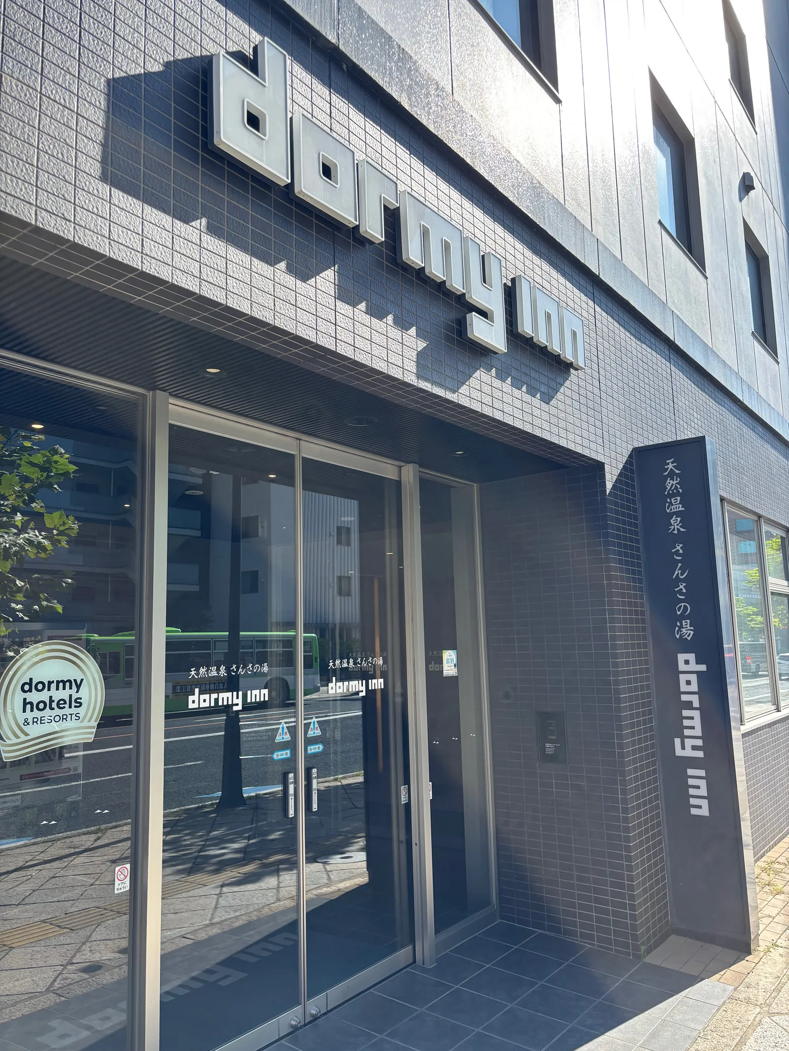 昼間のドーミーイン盛岡の外観。看板と入口が写っている
