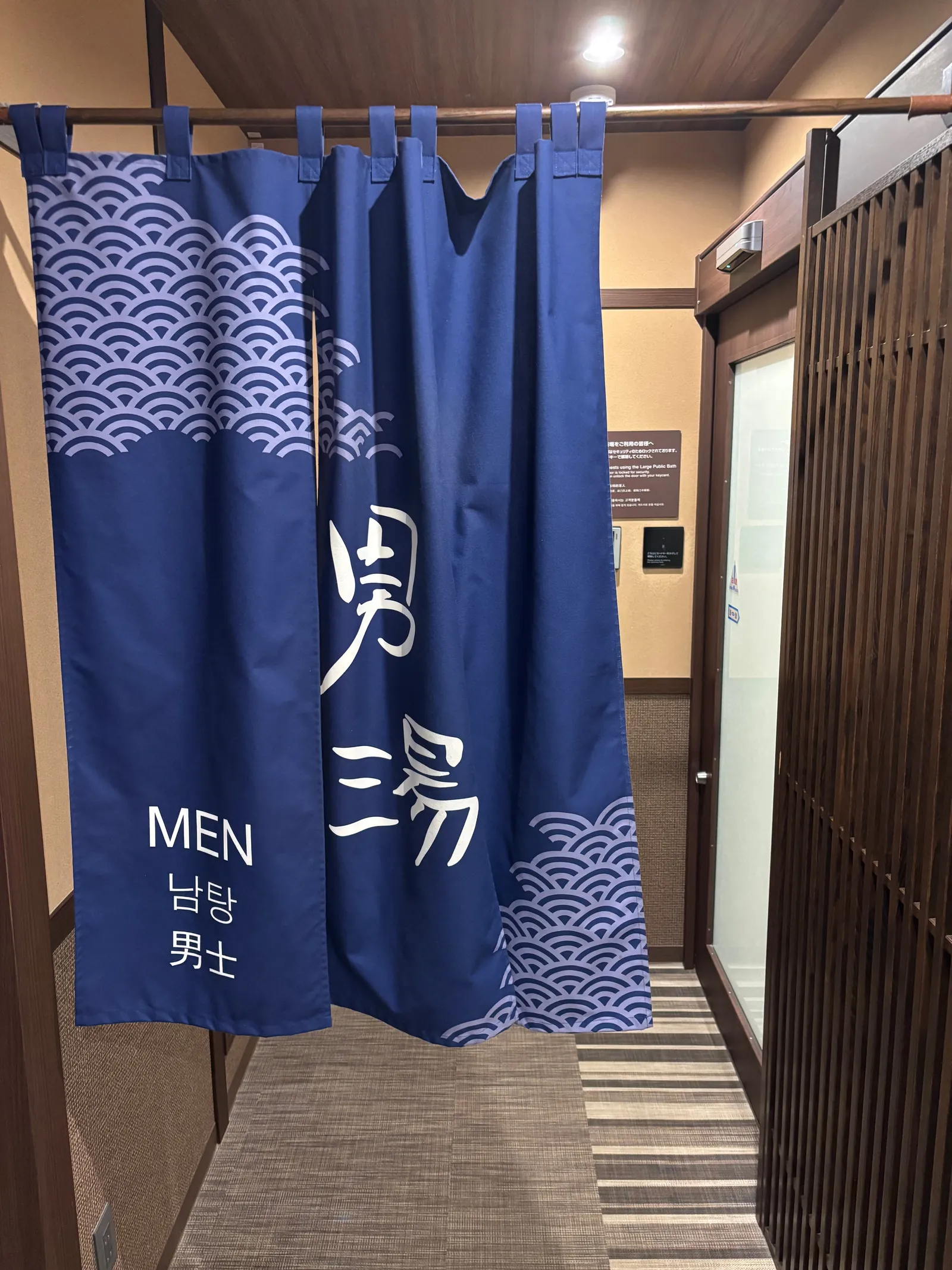 大浴場入口の暖簾。「男湯」と書かれた紺色の暖簾がかかっている