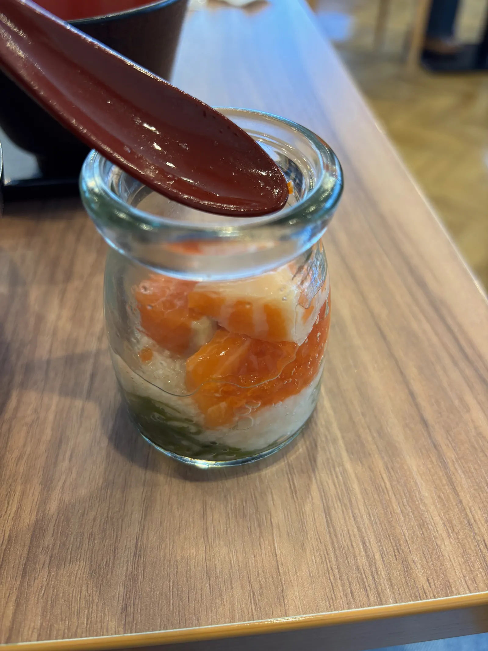小瓶に入った、サーモンといくらをのせたご飯